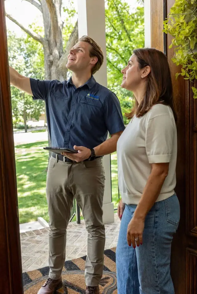 PMG technician pointing out the front door trim to a homeowner